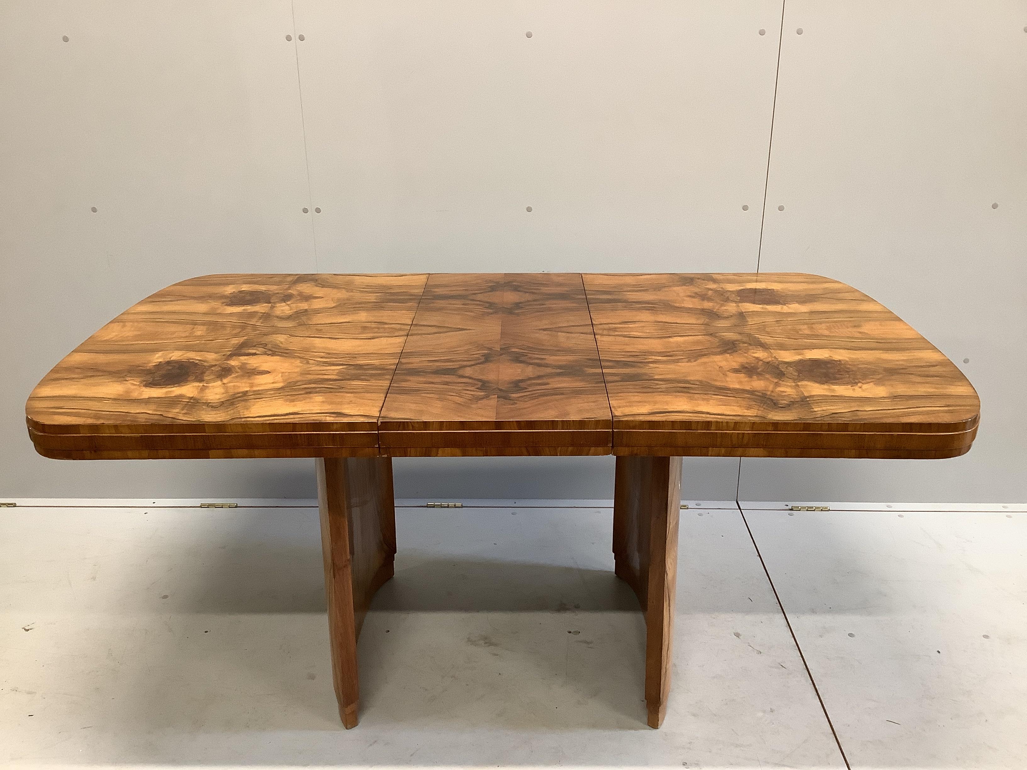 An Art Deco figured walnut rectangular extending dining table, length 167cm extended, one spare leaf, width 91cm, height 77cm